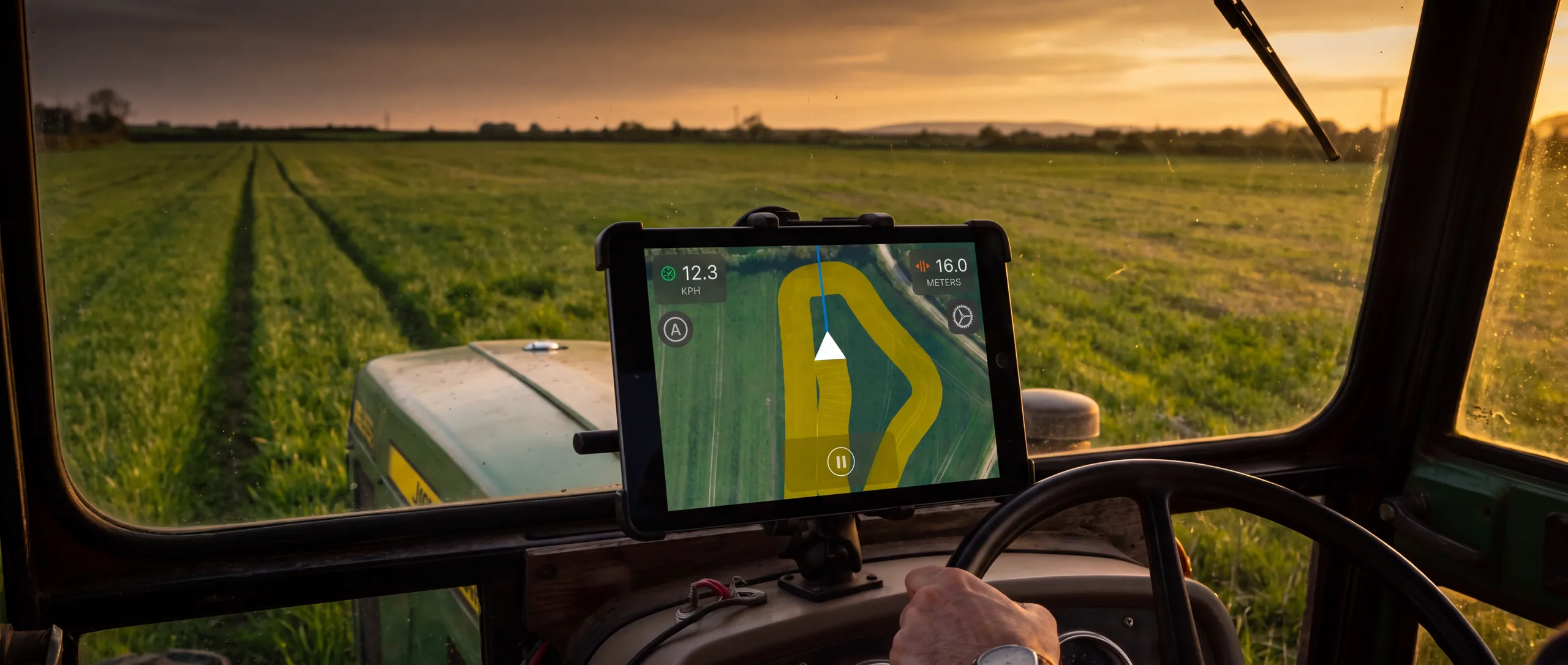 An iPad running Tractor GPS mounted in a tractor cab at dusk